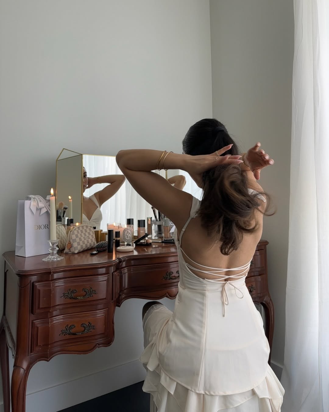 Mobina Peiman sits at her vintage vanity while doing her hair.