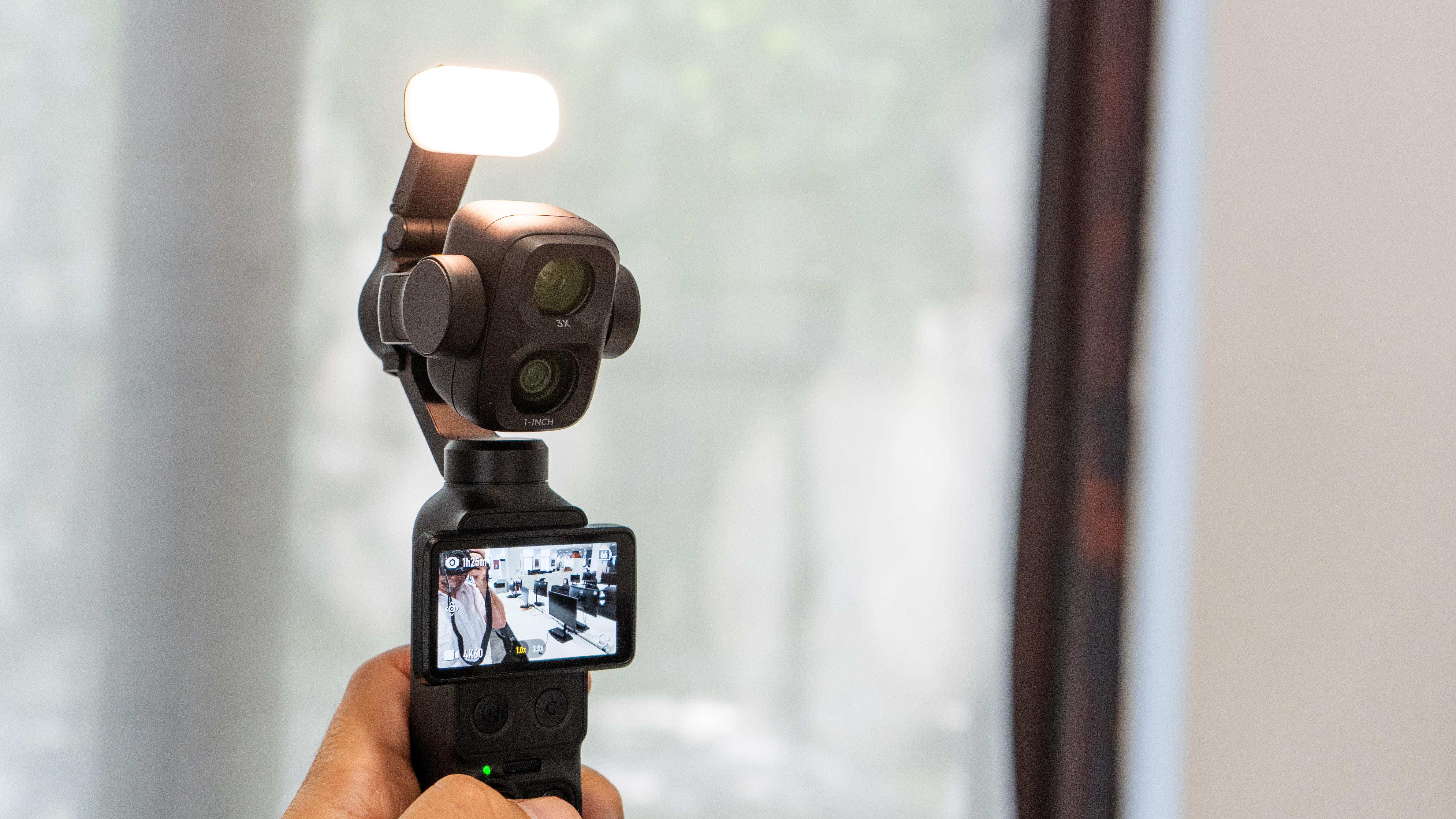 DJI Osmo Pocket 4P with the fill light accessory in my hand