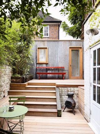 corrugated iron summer house on upper level of a small garden