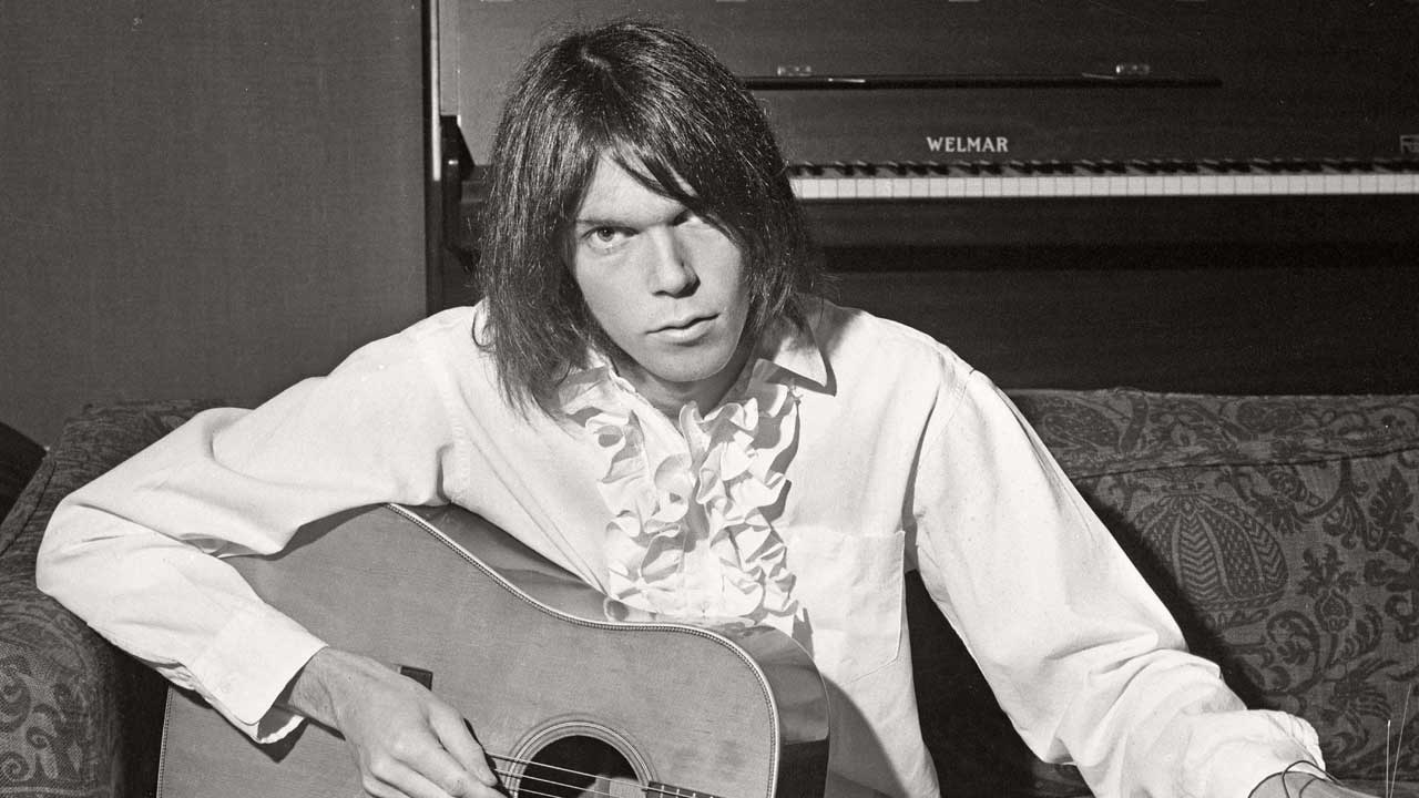 Neil Young playing an acoustic guitar