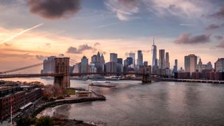 A photo of the Manhattan skyline from Brooklyn with the Brooklyn Bridge and East River in the foreground