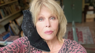 Joanna Lumley holding her shoes ahead of the auction.
