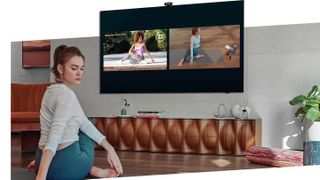 Someone stretching in front of yoga video on television