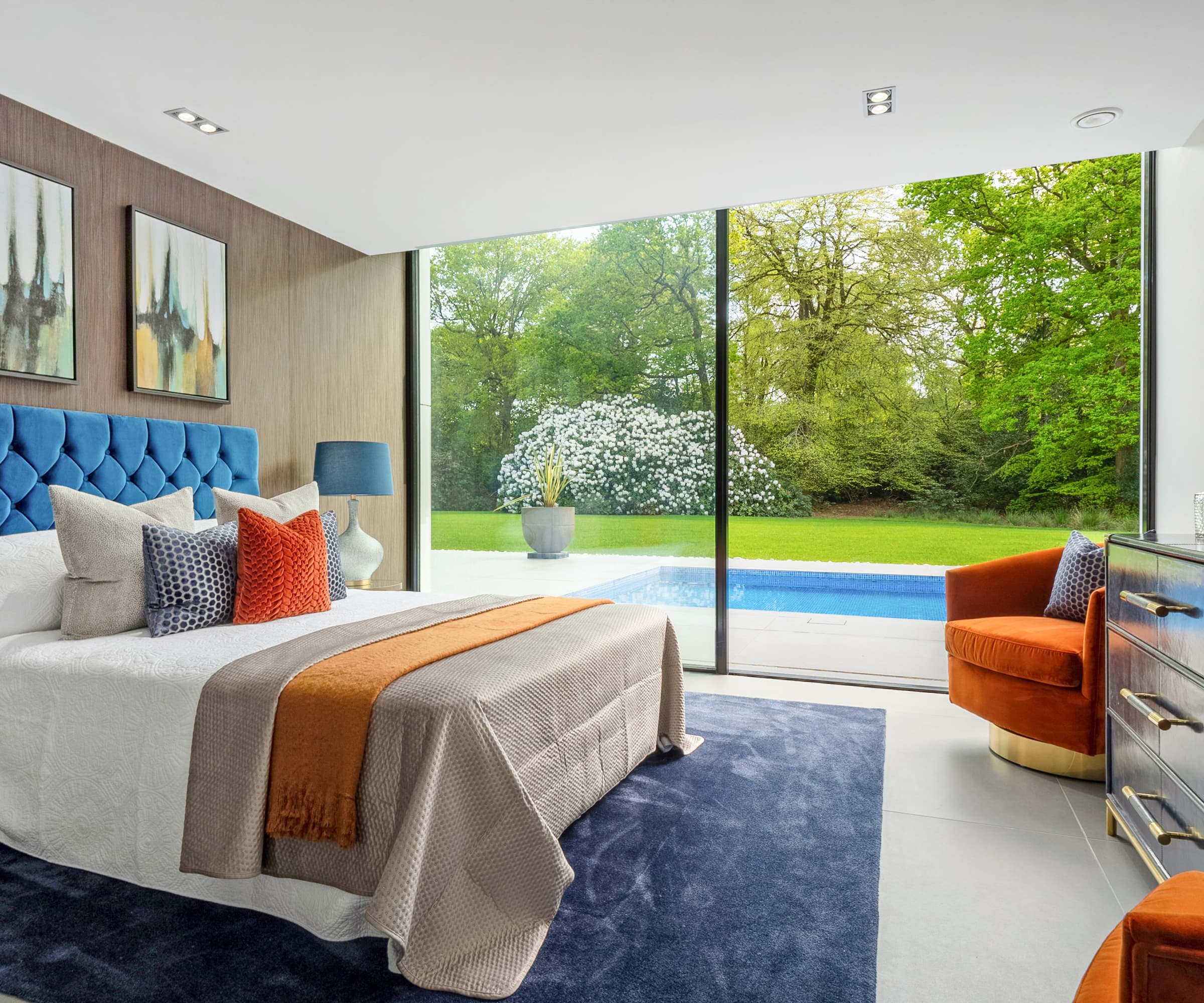 A bedroom with bifold doors leading to a pool