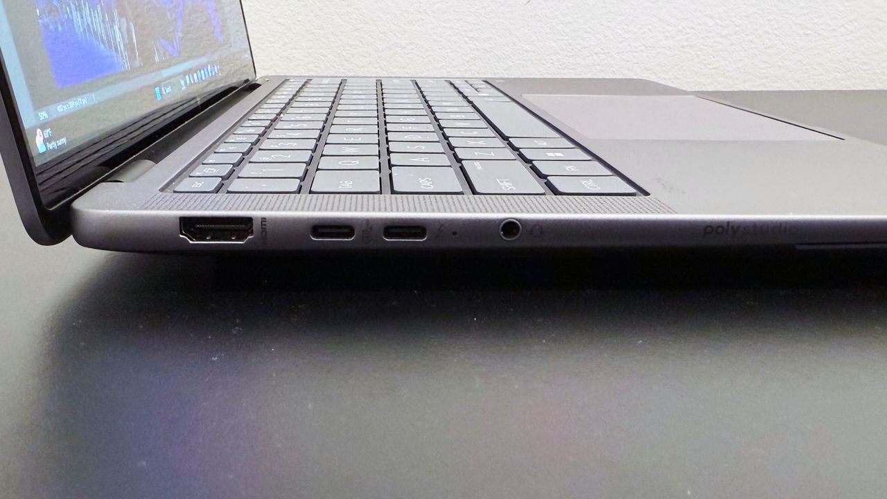 Close-up of the left-side ports on the HP ZBook Ultra 14 G1a mobile workstation open on a black desk against a white wall.