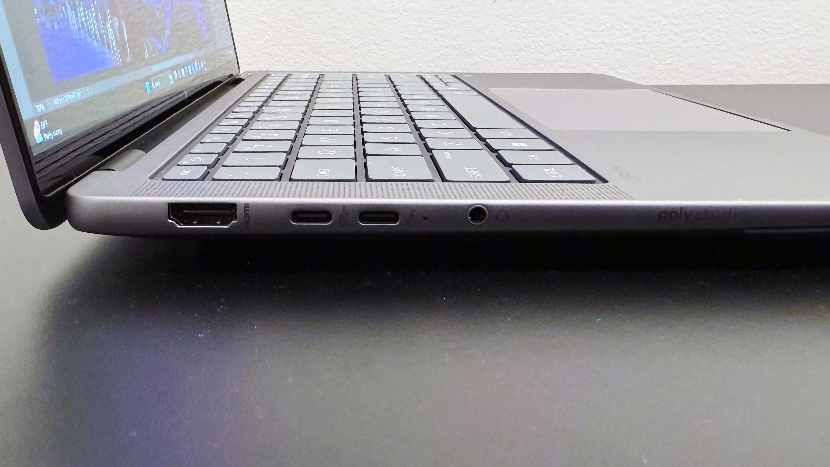 Close-up of the left-side ports on the HP ZBook Ultra 14 G1a mobile workstation open on a black desk against a white wall.