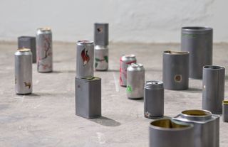 Assemblage of silver cans on the floor