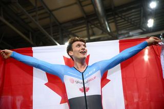 Canada's Dylan Bibic celebrates his victory with the Canadian national flag after winning the Mens Scratch Race