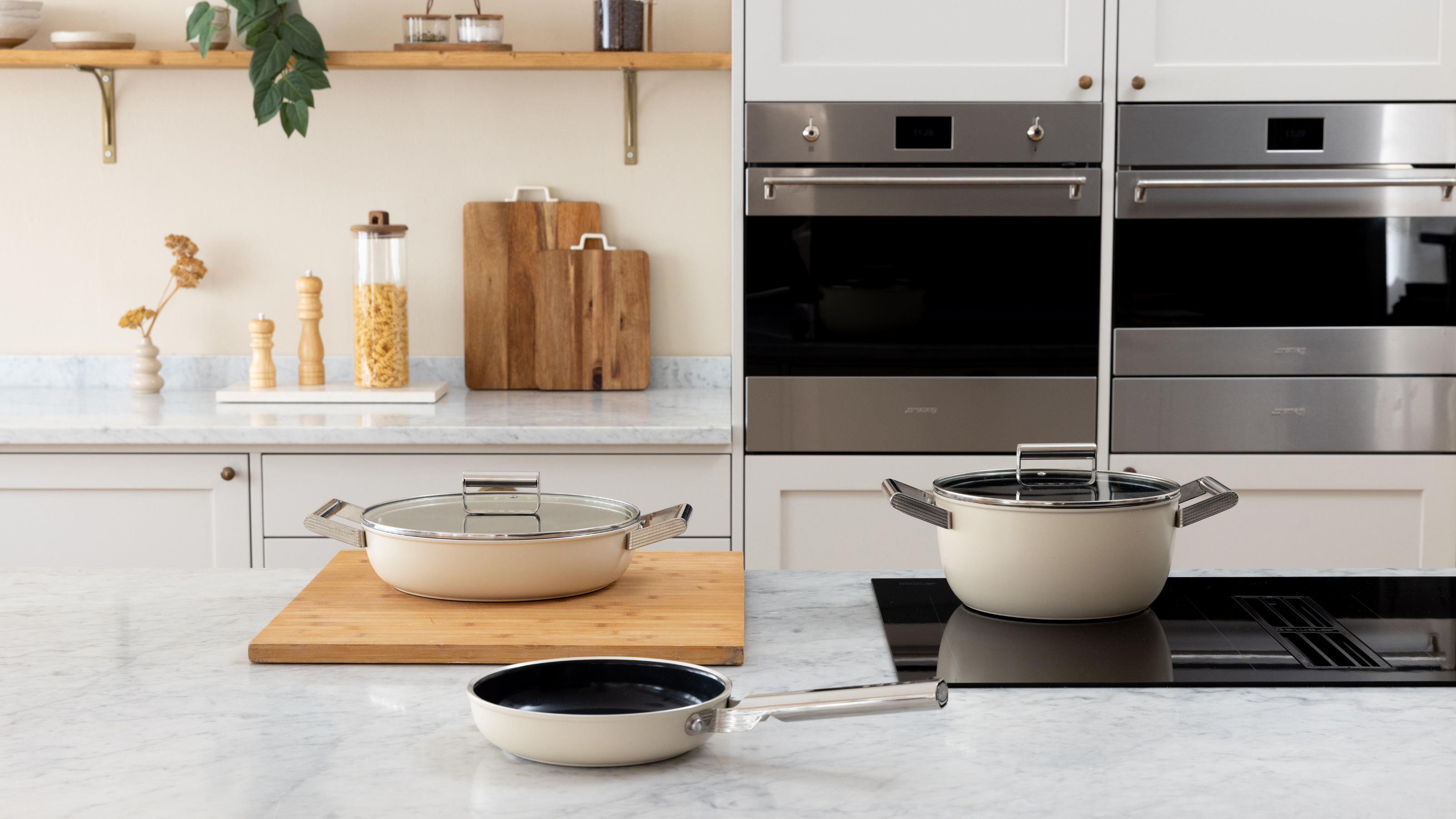 new smeg cookware launch with three cream-colored pots and pans