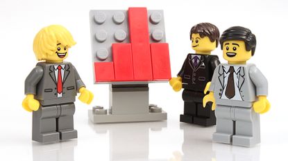 Lego minifigures of office men standing around a chart
