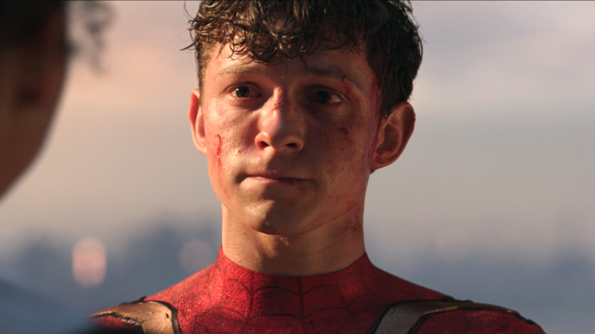 Tom Holland as Spider-Man at the end of No Way Home looking at Zendaya's MJ (off camera)