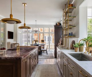 A Georgian-inspired kitchen with a brow island and gold finishes