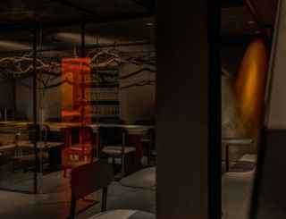 dimly lit interior of Bar Kinky, with branch sculptures and orange light