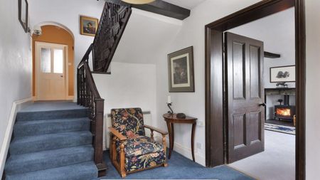 hallway with blue carpet and dark staircase