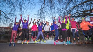 A group of women in running gear jump in unison