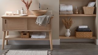 Japandi bathroom idea with natural wooden sink vanity unit with round wooden sink with hand towel and beauty products on the top