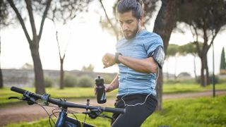 Cyclist checking GPS watch and frowning