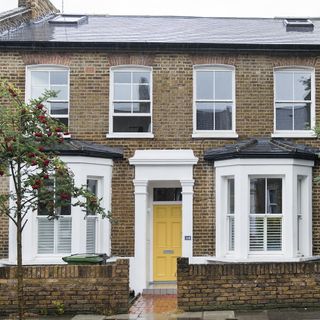 house exterior with white windows and yellow door