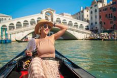 Woman on a gondola tour sailing in Grand Canal in Venice, Italy