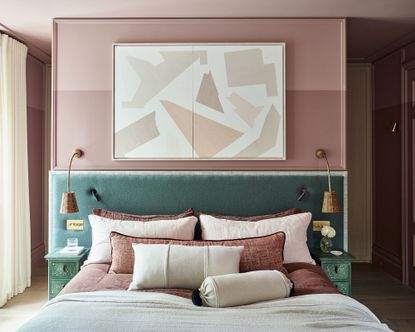 Pink bedroom with green velvet headboard and abstract art above bed