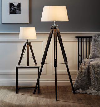 room with grey wall and tripod floor lamp and tripod table lamp and wooden floor