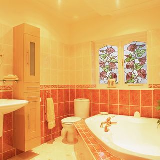 bathroom with yellow and orange tiled wall and white washbasin
