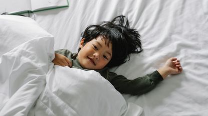 Young boy lying in bed