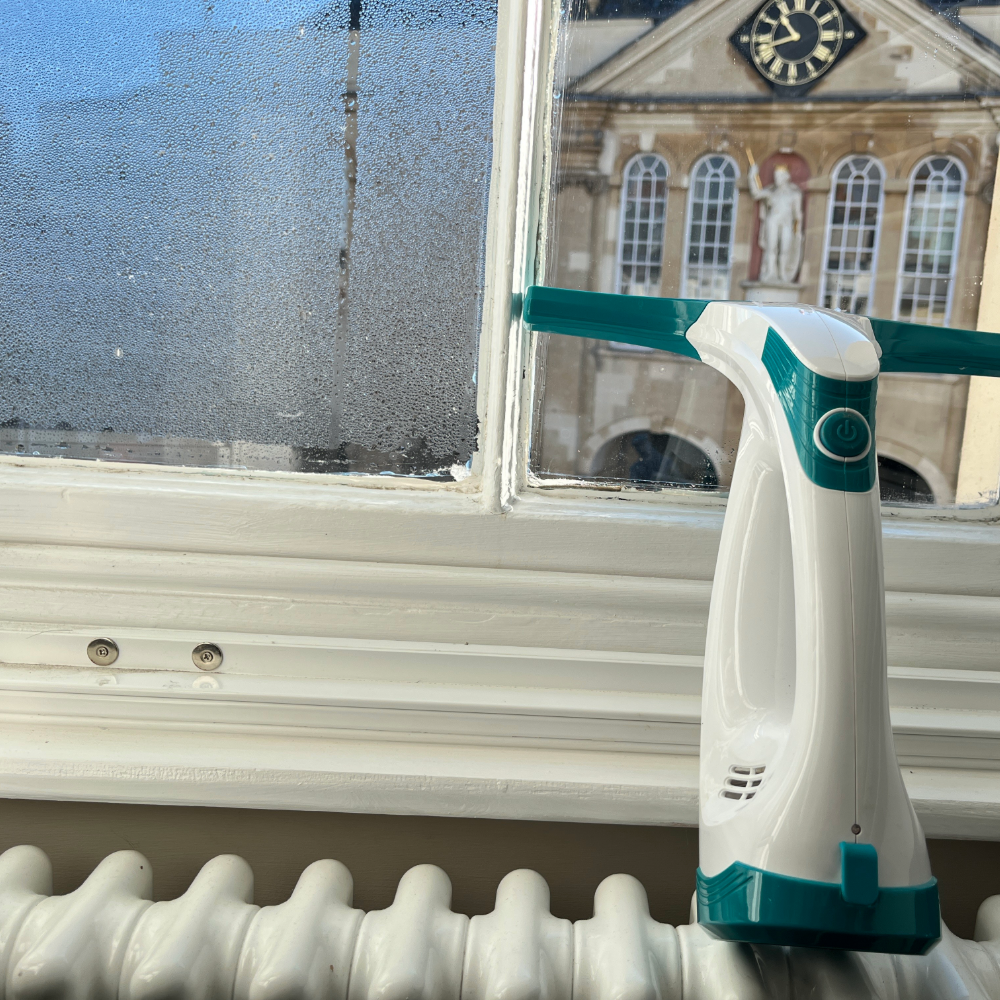 Beldray Window Vac balanced on the radiator next to a clear and foggy window