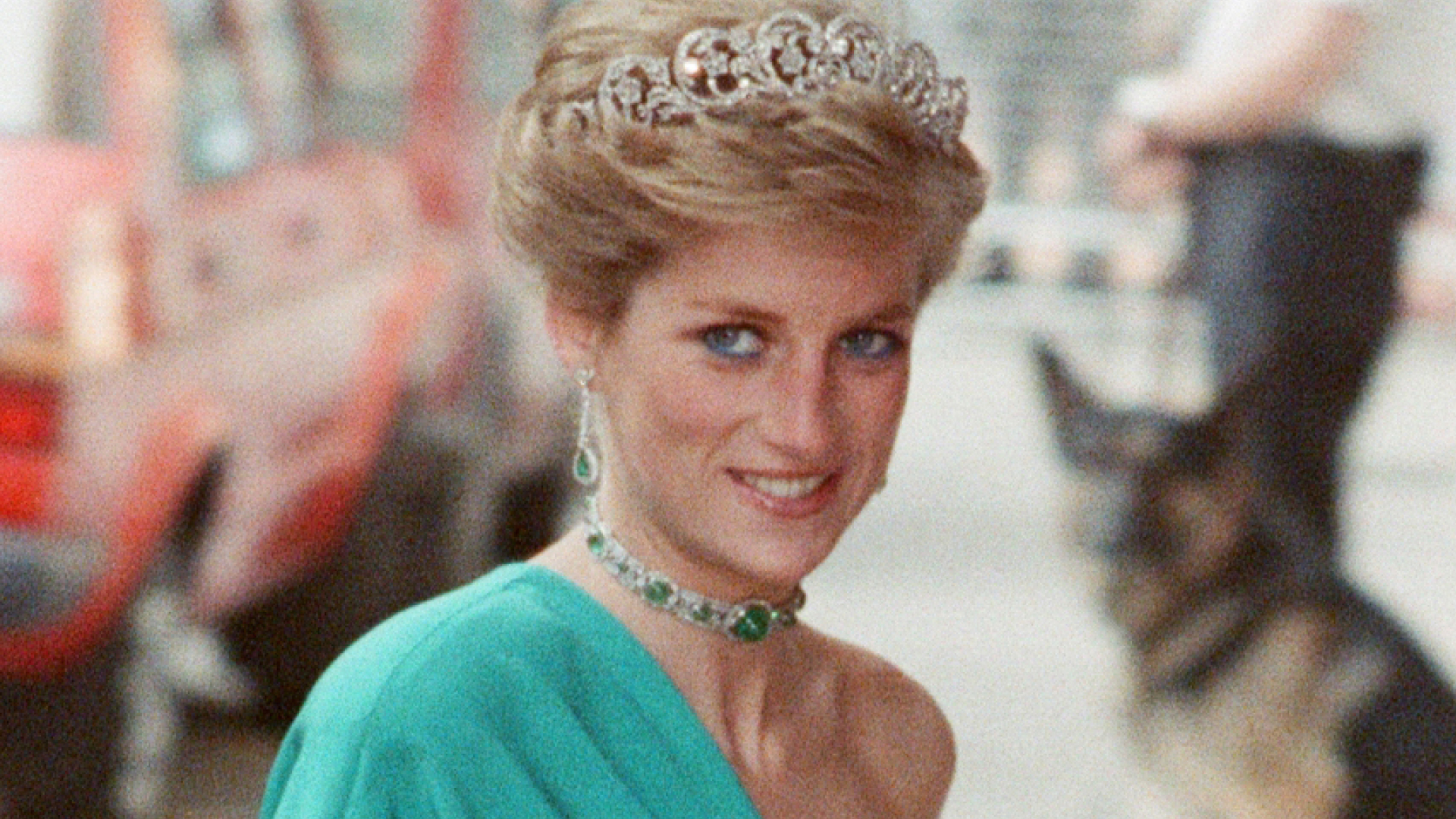 Princess Diana wears a one-shoulder green gown with a sparkling tiara