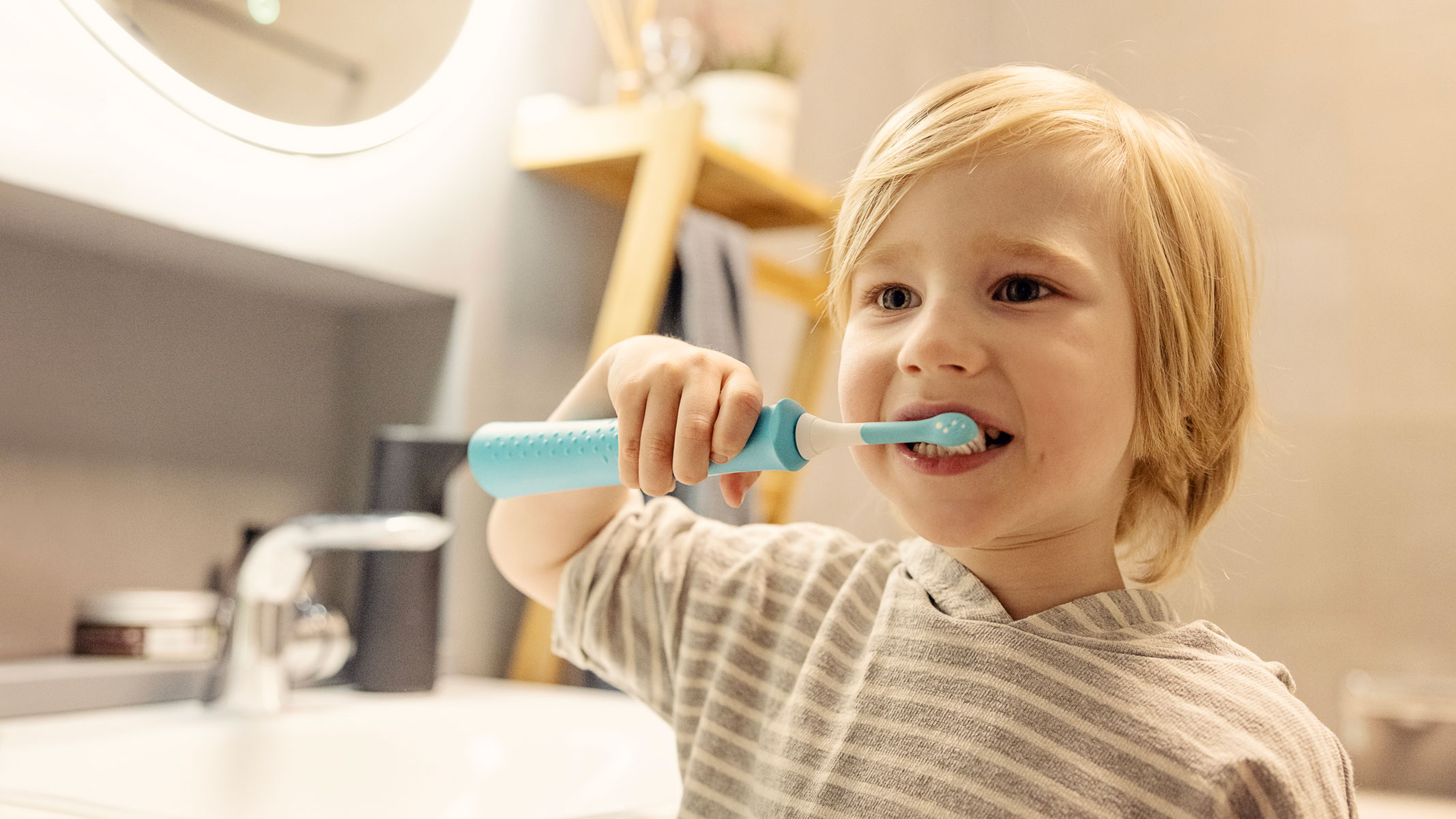 A picture of a toddler brushing his teeth with an electric toothbrush