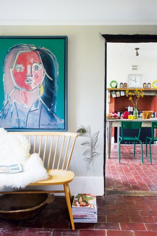 Abstract wall art with wooden Mid-century style bench in hallway in front of kitchen spacee in kitchen-diner