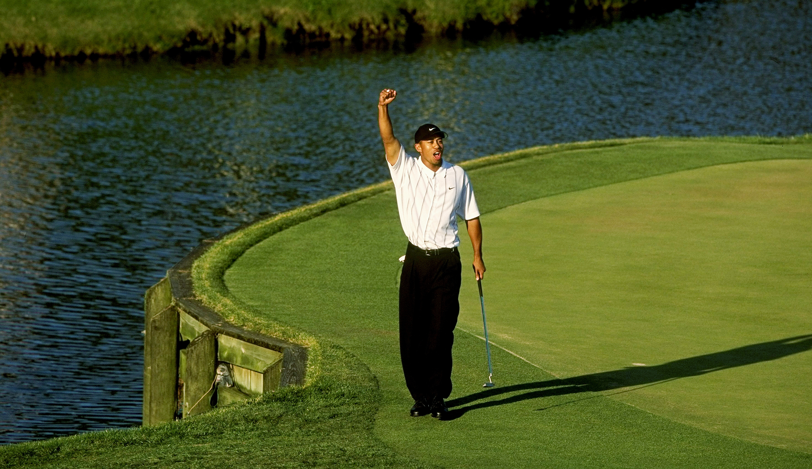 Tiger Woods raises his hands in the air