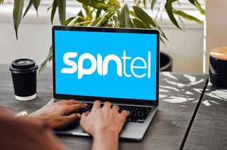 Spintel logo on laptop screen with woman typing on keyboard