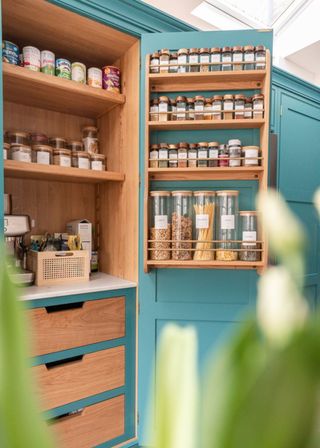 A large kitchen pantry with spices inside and other food elements.