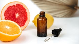 anti-aging skin care cosmetics with vitamin C serum or essential skin oil, dropper bottle and citrus lemon orange grapefruit, aromatherapy essential oil