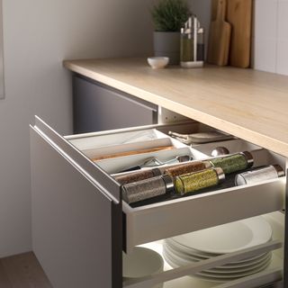 Open kitchen drawer with organiser that includes a space for spice jars