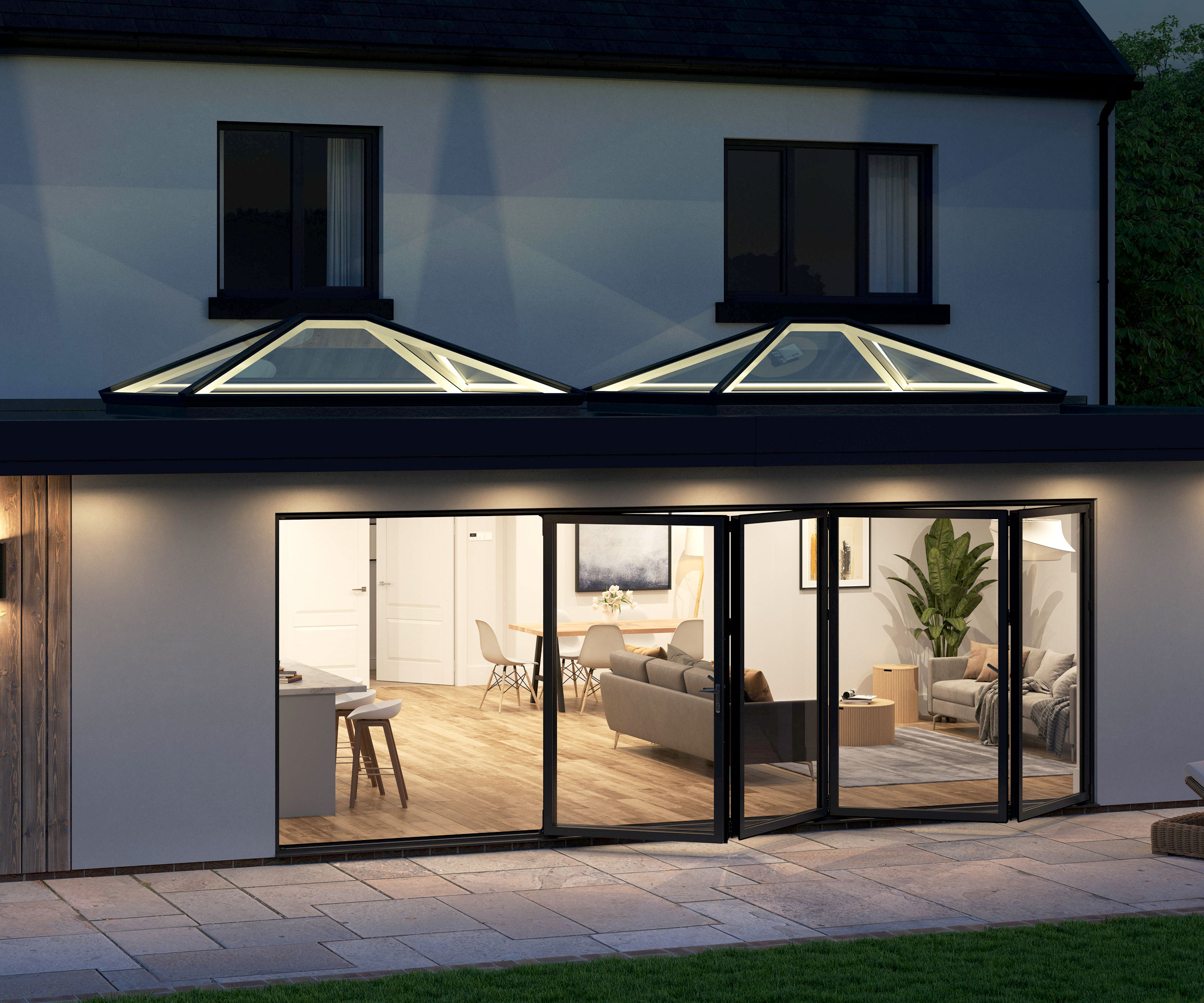 Outdoor shot of double Korniche roof lanterns with integrated LED lighting, illuminating a contemporary extension with bi-fold doors