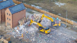 Two bulldozers destroying houses on Darwin Green Estate