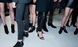 Models wearing all-black footwear, low ankle boots, and strappy sandals, from the Costume National A/W 2015 collection.