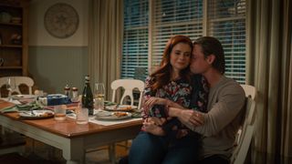 JoAnna Garcia Swisher as Maddie Townsend sitting on Justin Bruening as Cal Maddox in their kitchen in sweet magnolia season 4