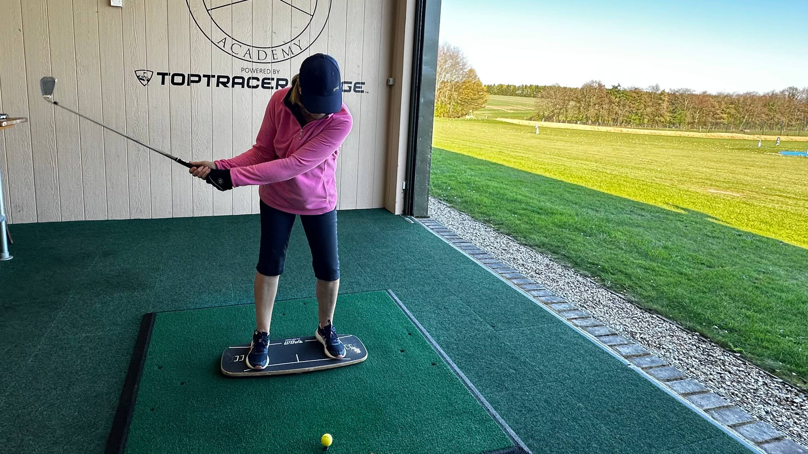 Female golfer using balance board training aid