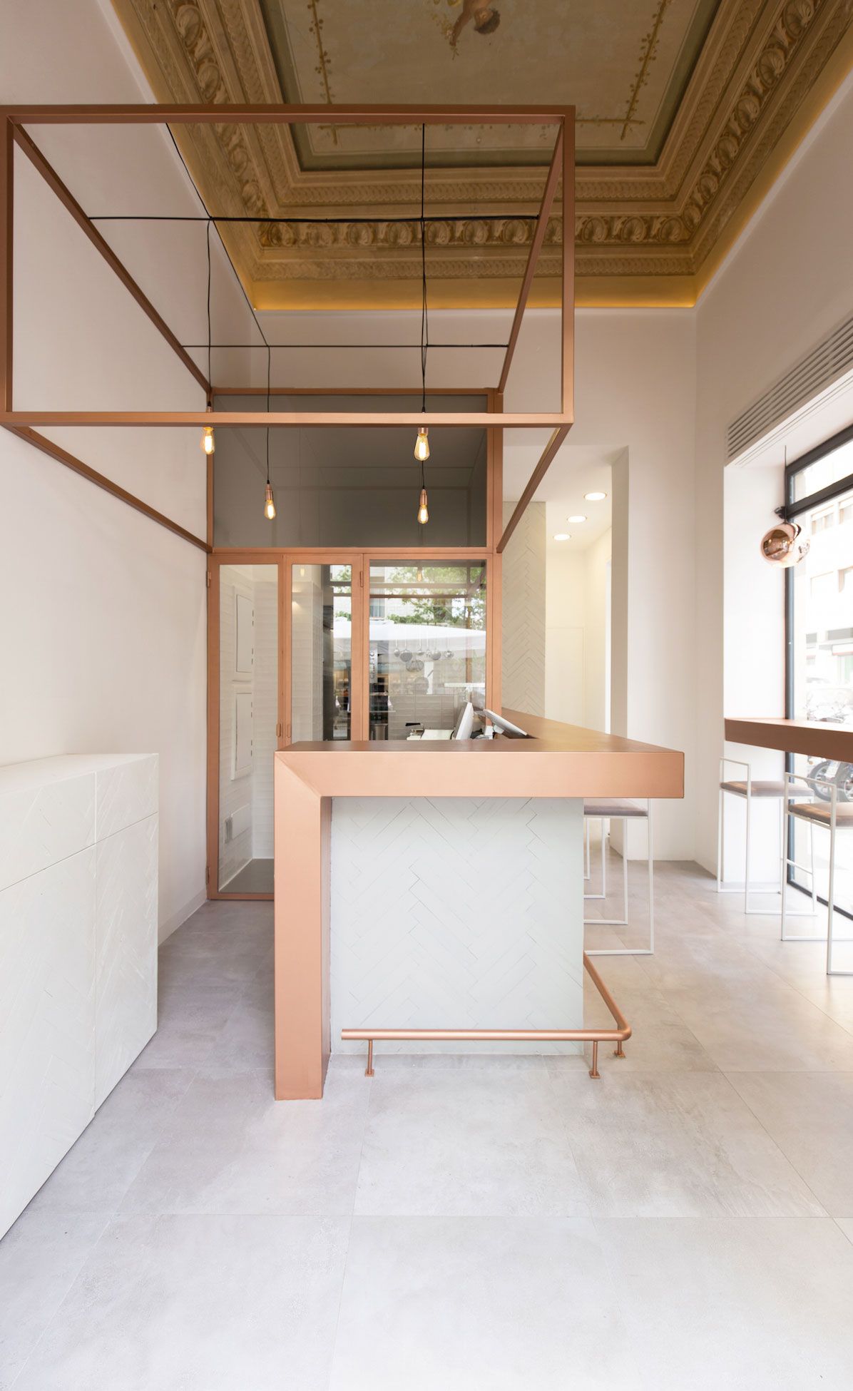 bar inside of Tritalo features a rose gold countertops with with white herring bone pattern tiles