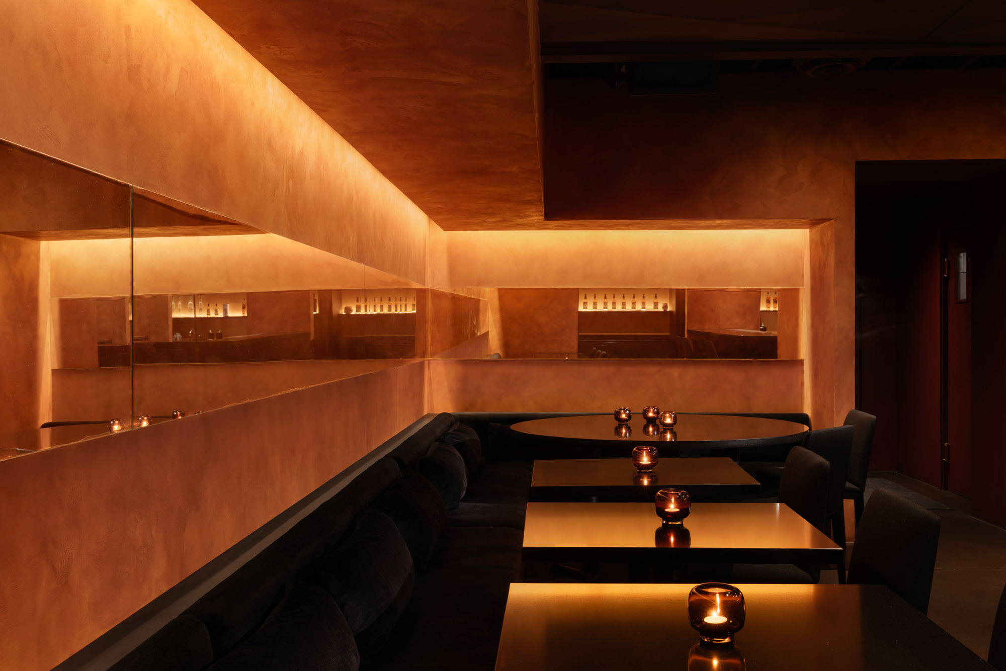 Different seating options at Ama Bar, all enveloped by an orange atmosphere