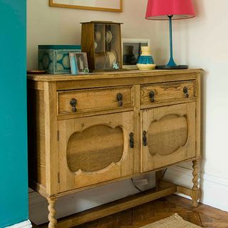 wooden sideboard with lamp and wooden flooring