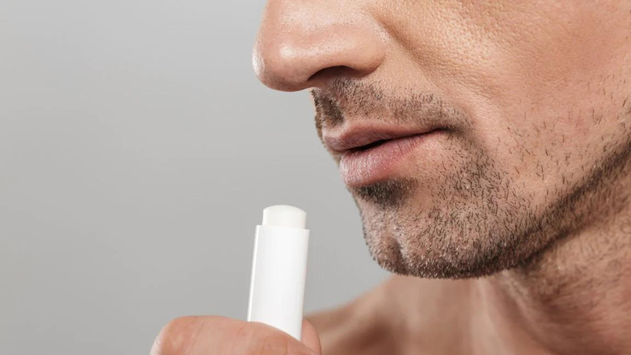 man putting lip balm on