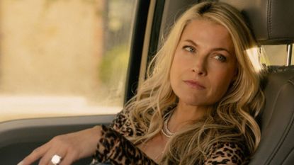 Ali Larter looks over to a car's driver's seat 