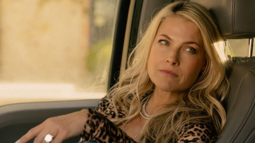 Ali Larter looks over to a car's driver's seat 