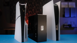A side-by-side comparison from left to right of the PS5 slim, Not From Concentrate's tiny PS5 rebuild, and a standard, fullsize PS5 on top of a blue desk.