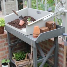 Potting bench area with seedlings and terracotta pots at RHS Chelsea Flower Show 2023