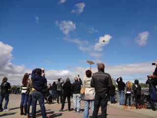 A crowd watches space shuttle Enterprise fly over New York.